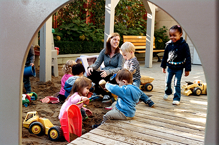 Children playing in the sandbox supervised by an Early Childhood Educator