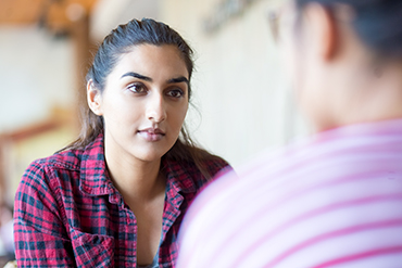 Image of two educators sitting and having a conversation