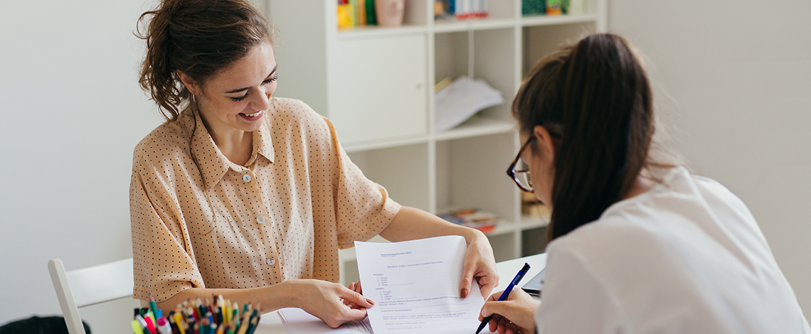 A woman showing a report to a colleague.